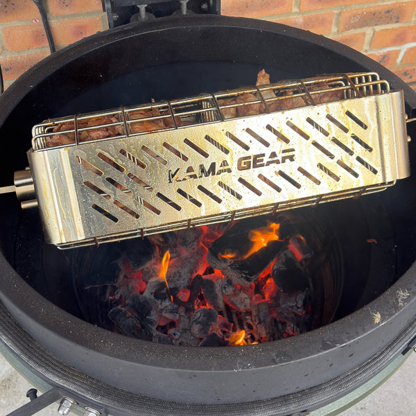 KAMA GEAR rotisserie cage spanning an open kamado, with the branded side panel facing forwards.