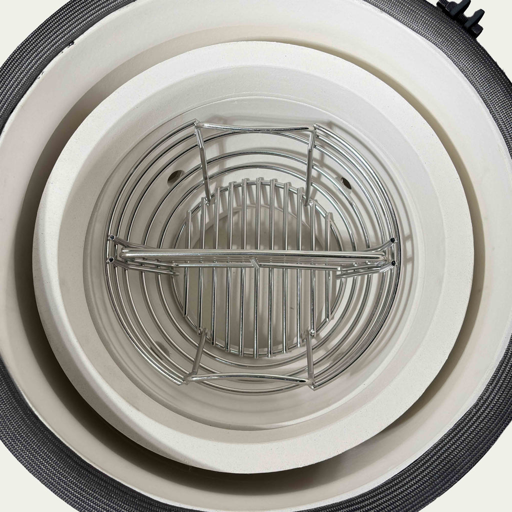 Top view of the V2 Mini charcoal basket and divider inside the ceramic fire bowl.