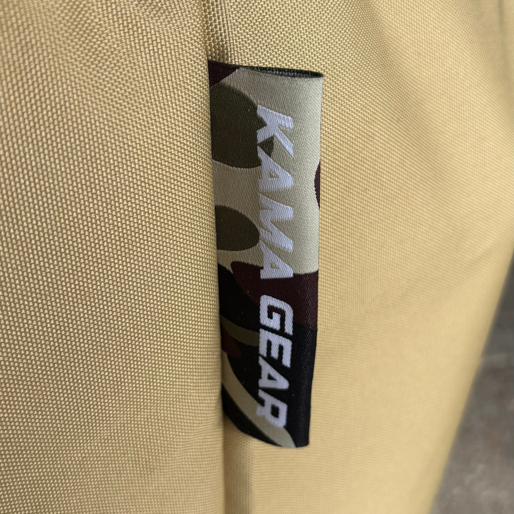 Close-up of the KAMA GEAR label sewn into the khaki grill cover.