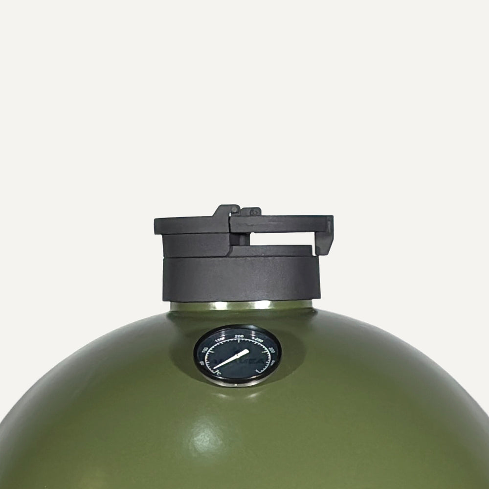 Close-up of the KAMA GEAR Pro Cap and thermometer on an olive-green kamado dome.