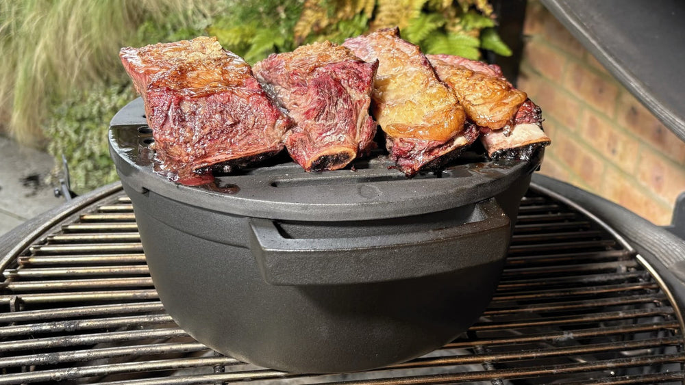 Beef short ribs on a grate above a KAMA GEAR SmokePot inside an open kamado.